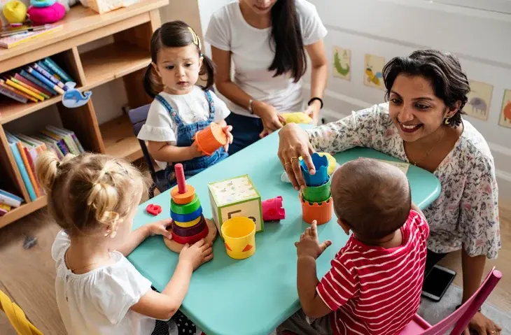 Daycare children with autism playing with teacher in the classroom